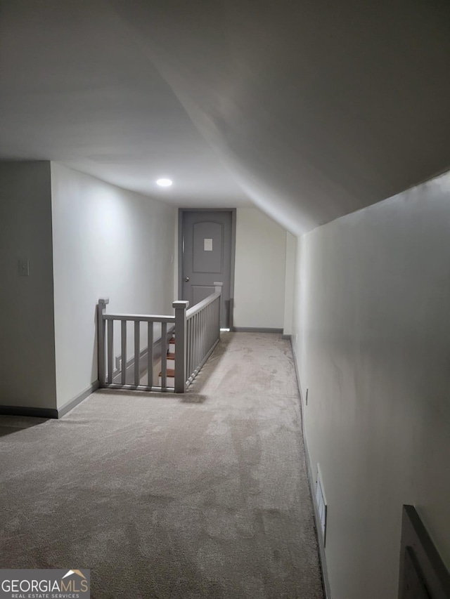 additional living space featuring light carpet and vaulted ceiling