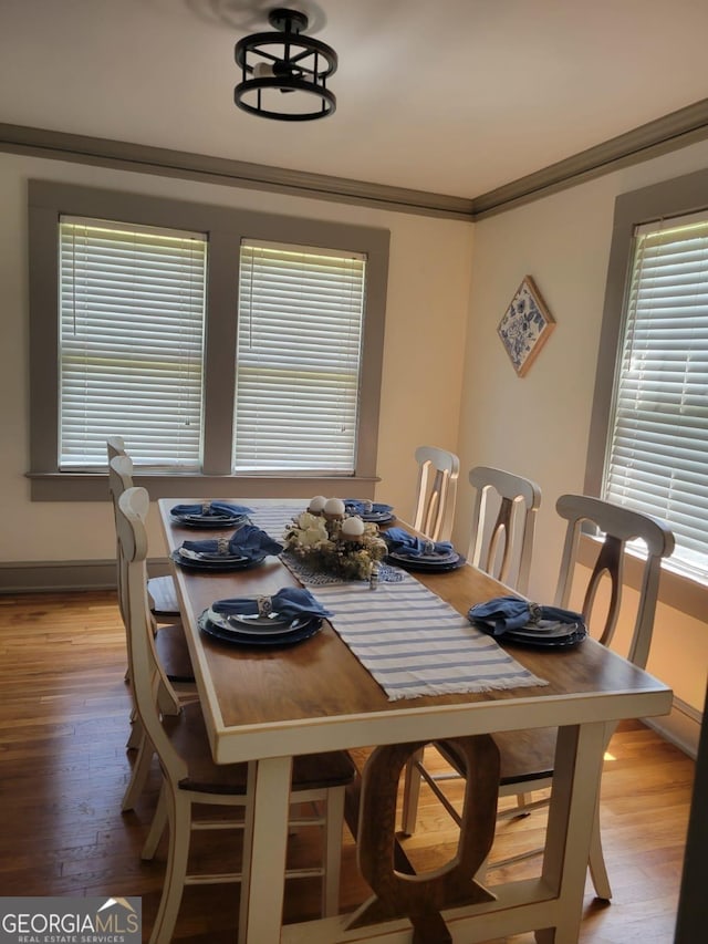 dining room featuring a wealth of natural light, hardwood / wood-style floors, and crown molding