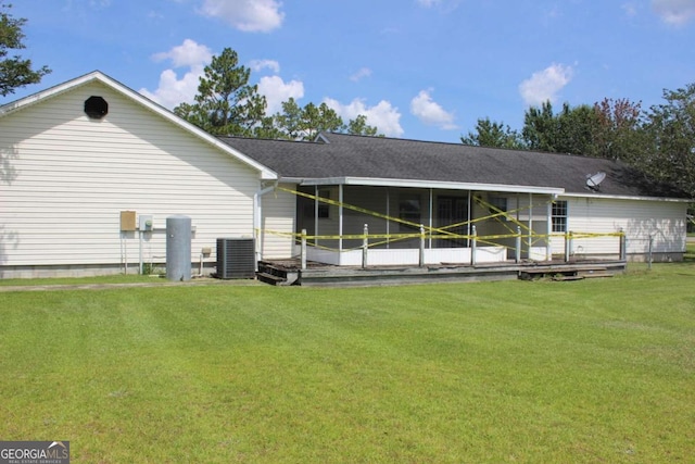 rear view of property with a wooden deck, central AC unit, and a lawn