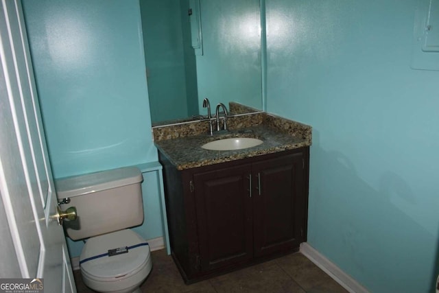 bathroom featuring vanity, electric panel, tile patterned floors, and toilet