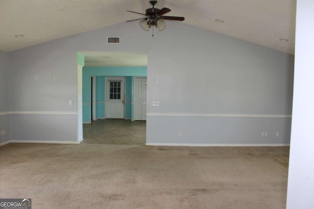 carpeted spare room featuring vaulted ceiling and ceiling fan