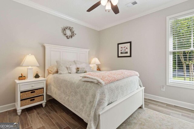 bedroom with ceiling fan, crown molding, and wood-type flooring