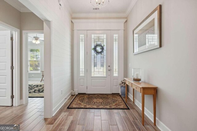 entryway with ceiling fan, ornamental molding, and hardwood / wood-style flooring