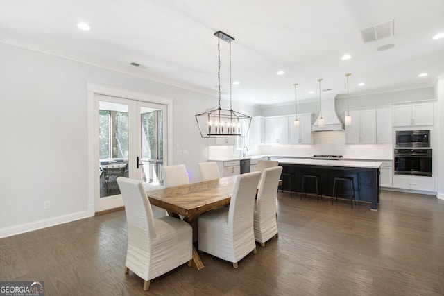 dining area featuring french doors, ornamental molding, and dark wood-type flooring