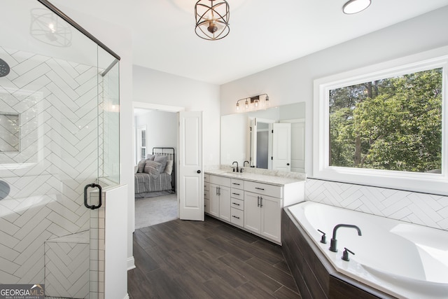 bathroom with hardwood / wood-style floors, vanity, and independent shower and bath