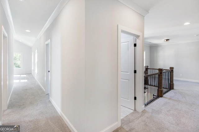 corridor featuring crown molding, light carpet, and vaulted ceiling