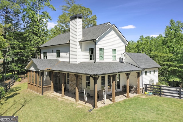 back of property featuring a yard, a patio, and a sunroom