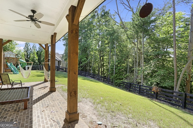 view of yard with ceiling fan, a playground, and a patio