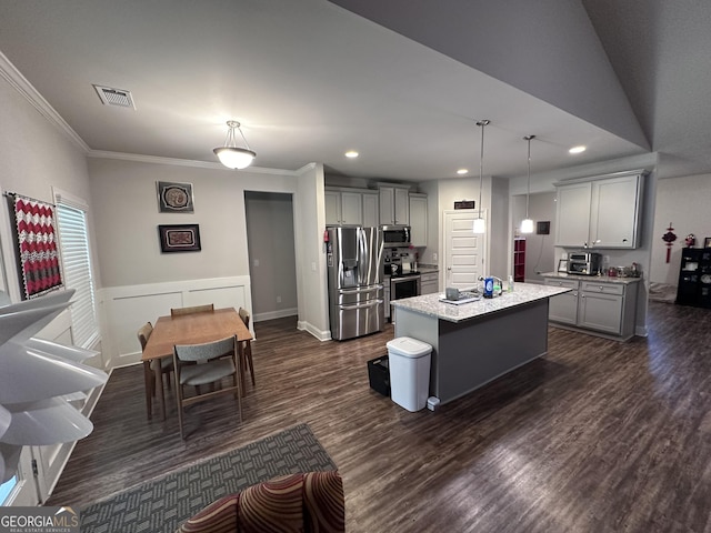 kitchen featuring appliances with stainless steel finishes, a kitchen island with sink, dark wood-type flooring, gray cabinets, and hanging light fixtures