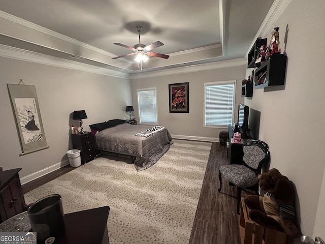 bedroom featuring a tray ceiling, ceiling fan, dark hardwood / wood-style flooring, and ornamental molding