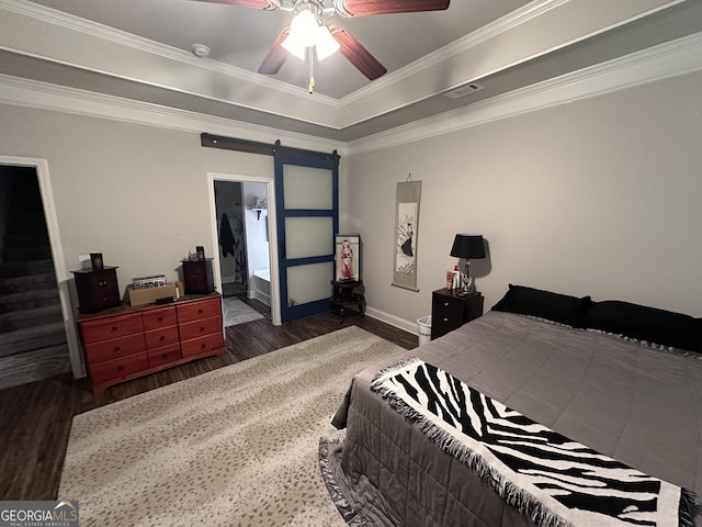 bedroom with a barn door, ceiling fan, dark hardwood / wood-style flooring, and ornamental molding