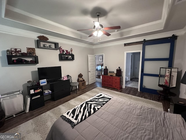 bedroom with a barn door, dark hardwood / wood-style floors, a raised ceiling, and ceiling fan