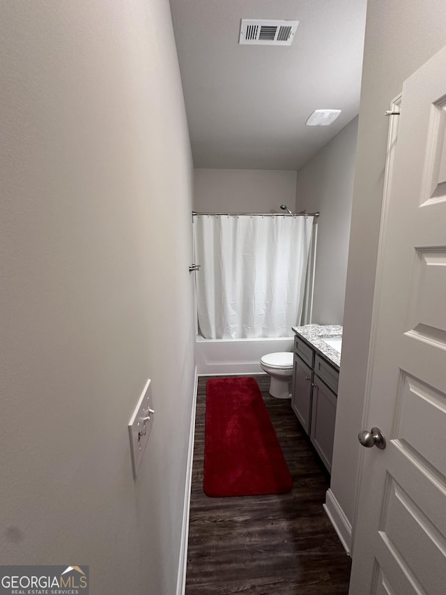 full bathroom with hardwood / wood-style floors, vanity, toilet, and shower / bath combo