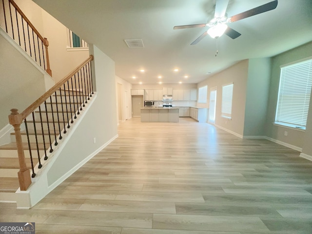 unfurnished living room with ceiling fan and light hardwood / wood-style flooring