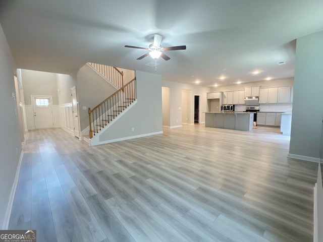 unfurnished living room featuring light hardwood / wood-style floors and ceiling fan