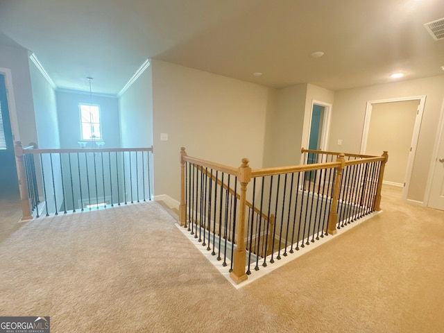 hall with ornamental molding and light carpet