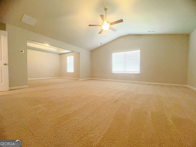 empty room featuring carpet, ceiling fan, and vaulted ceiling