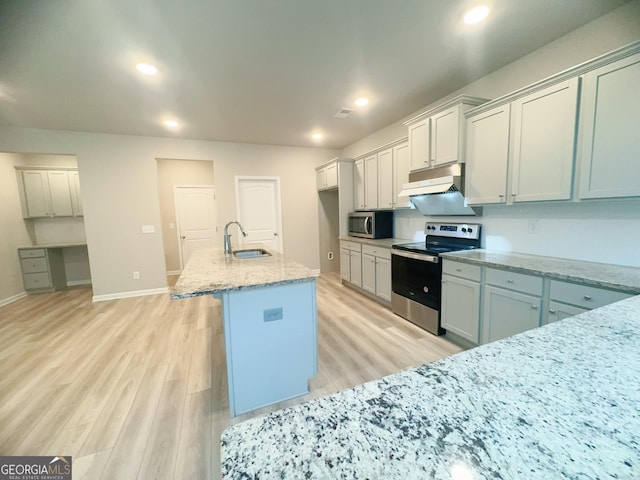 kitchen featuring a center island with sink, light wood-type flooring, sink, and appliances with stainless steel finishes