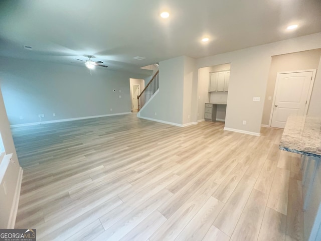 unfurnished living room with ceiling fan and light wood-type flooring