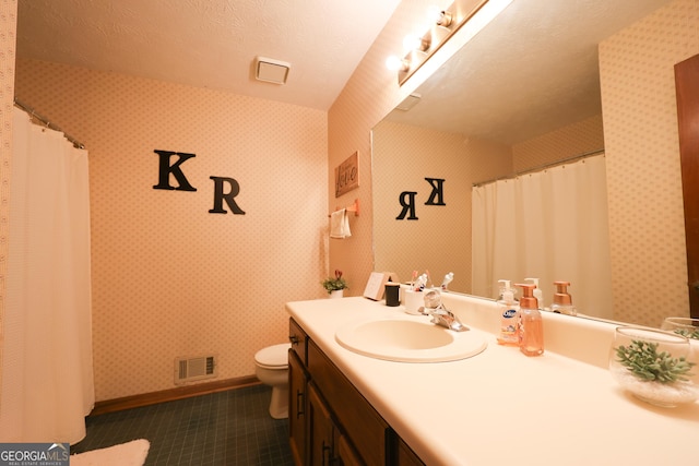 bathroom featuring vanity, a textured ceiling, and toilet