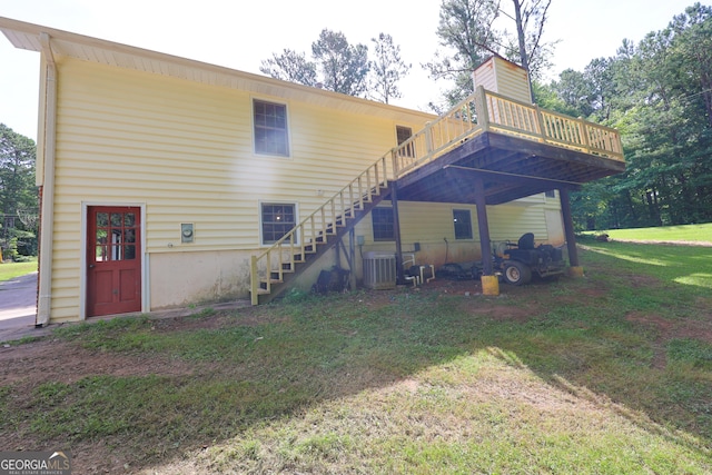 back of house with a deck, central AC unit, and a lawn