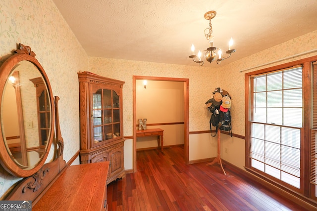 interior space with a notable chandelier, dark hardwood / wood-style floors, and a textured ceiling