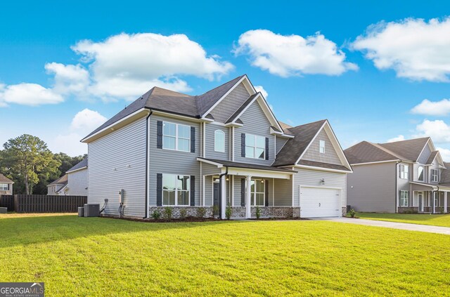 view of front of home with a front yard, a garage, and central AC unit