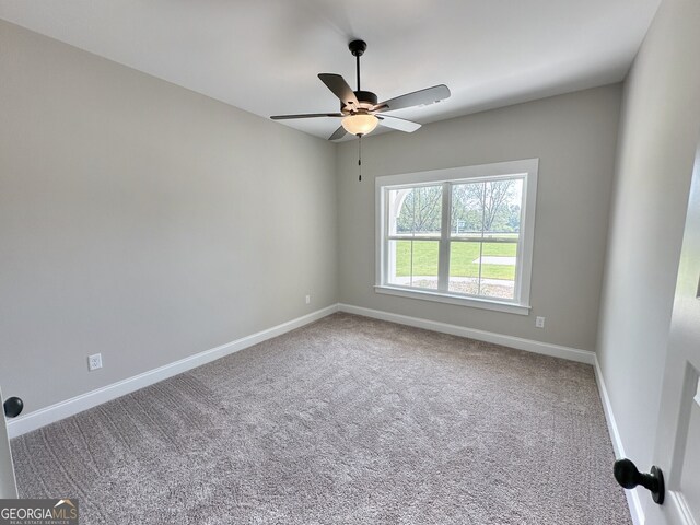 carpeted spare room with ceiling fan