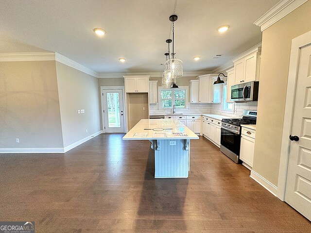 kitchen featuring white cabinets, a kitchen island, dark hardwood / wood-style flooring, pendant lighting, and stainless steel appliances