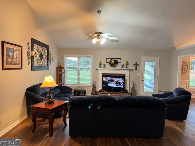 living room featuring a healthy amount of sunlight, lofted ceiling, ceiling fan, and dark hardwood / wood-style flooring