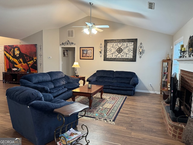 living room featuring dark hardwood / wood-style floors, ceiling fan, vaulted ceiling, and a fireplace