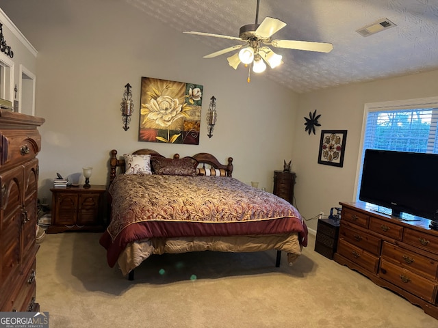 bedroom with ceiling fan, vaulted ceiling, a textured ceiling, and carpet flooring