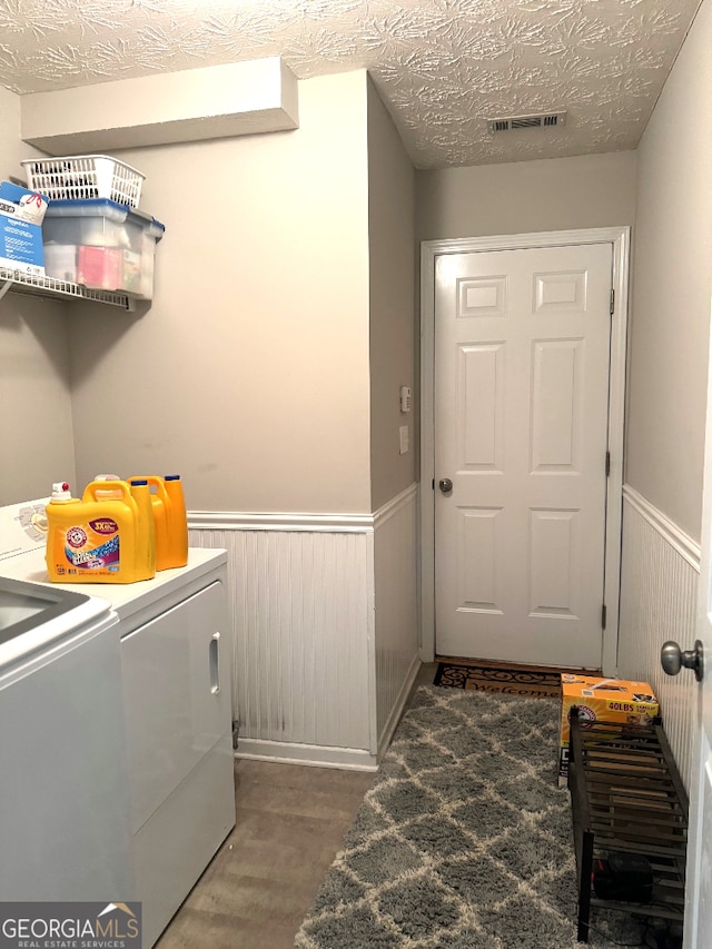 laundry area featuring independent washer and dryer, a textured ceiling, and hardwood / wood-style floors