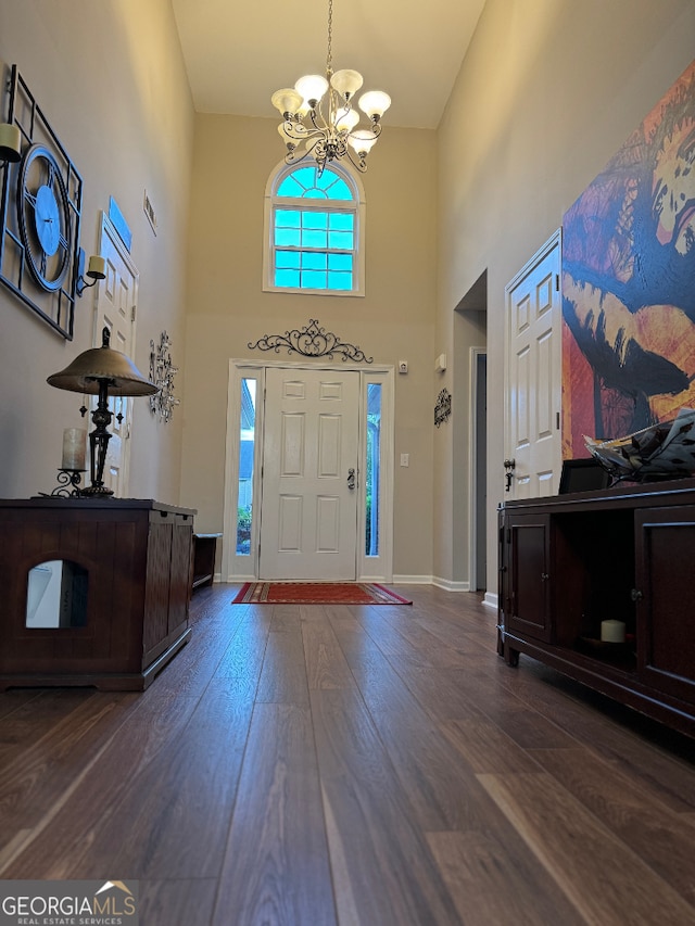 foyer entrance featuring a high ceiling, a chandelier, and dark hardwood / wood-style floors