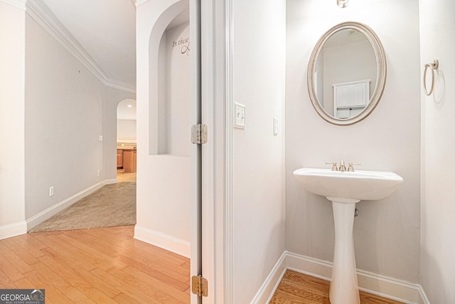 bathroom with wood-type flooring and ornamental molding