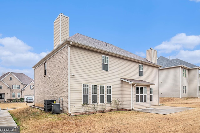 back of property with a patio, a yard, and central AC unit