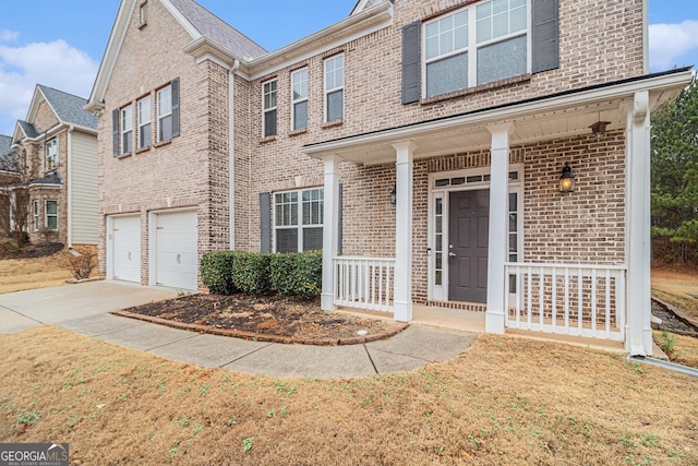 view of front of home with a garage, covered porch, and a front yard