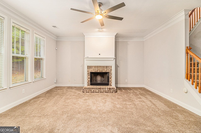 unfurnished living room with a brick fireplace, carpet floors, ornamental molding, and ceiling fan