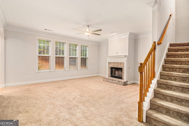 unfurnished living room with crown molding, a brick fireplace, light carpet, and ceiling fan