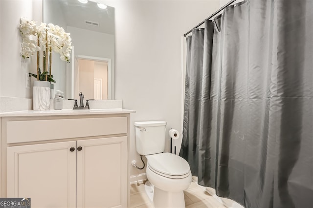 bathroom with tile flooring, vanity with extensive cabinet space, and toilet