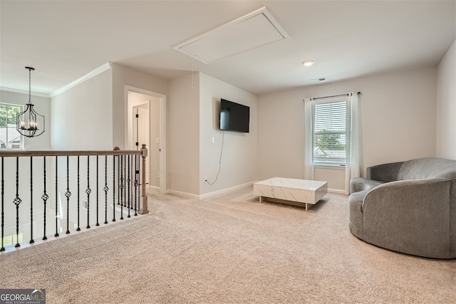 sitting room featuring plenty of natural light, ornamental molding, carpet, and an inviting chandelier