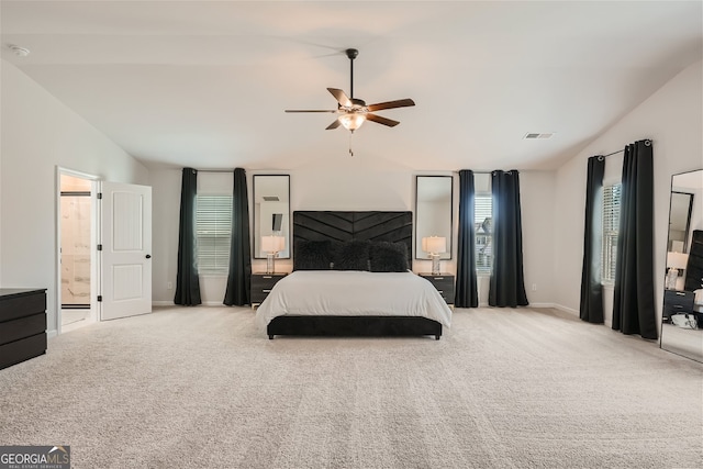 carpeted bedroom featuring connected bathroom, a ceiling fan, visible vents, vaulted ceiling, and baseboards