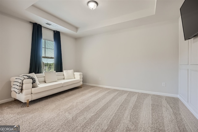 unfurnished room featuring carpet flooring, a raised ceiling, visible vents, and baseboards