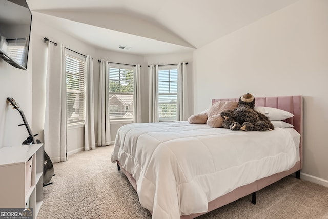 bedroom featuring vaulted ceiling and light carpet