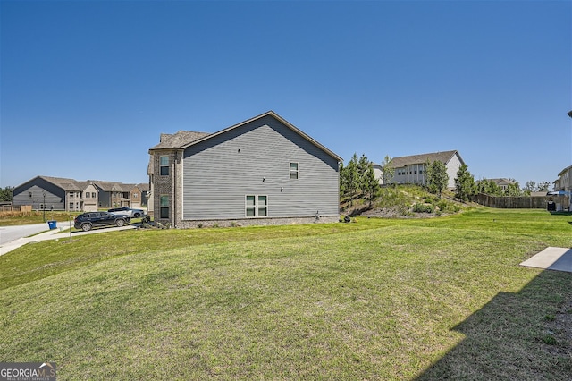 view of side of home with a residential view and a lawn