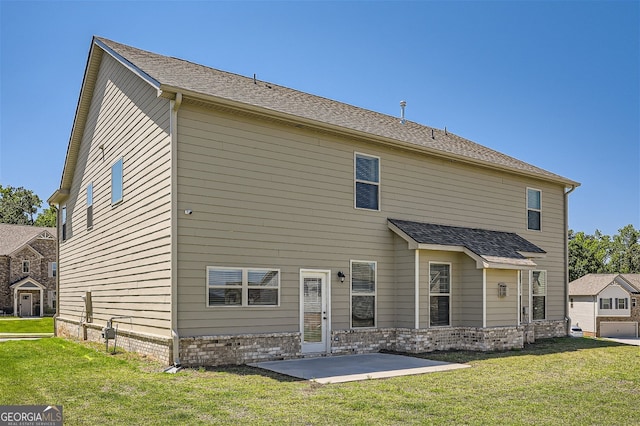 rear view of house featuring a yard, a garage, and a patio