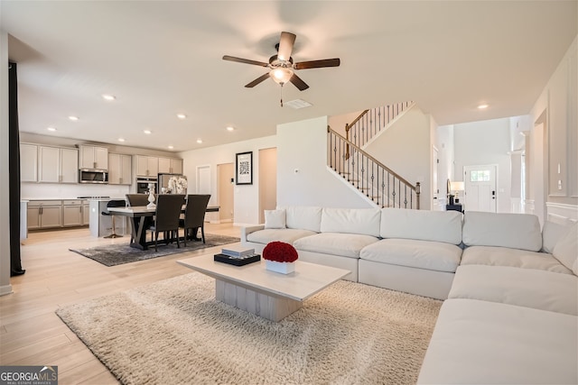 living area featuring stairway, recessed lighting, visible vents, and light wood-style flooring