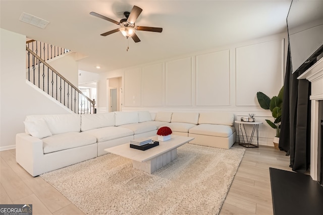 living room with ceiling fan and light wood-type flooring