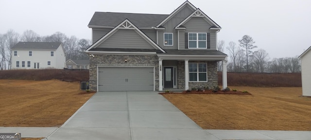 craftsman house with a garage, central air condition unit, and a front yard