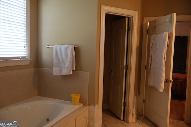 bathroom with tile patterned floors and a bath